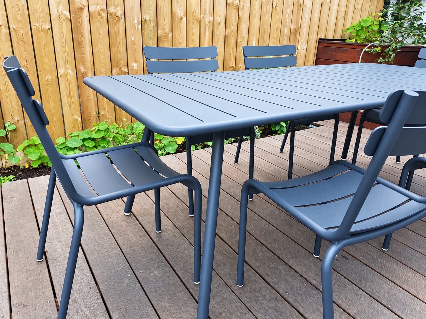 Table et chaises Fermob Luxembourg sur une terrasse en bois