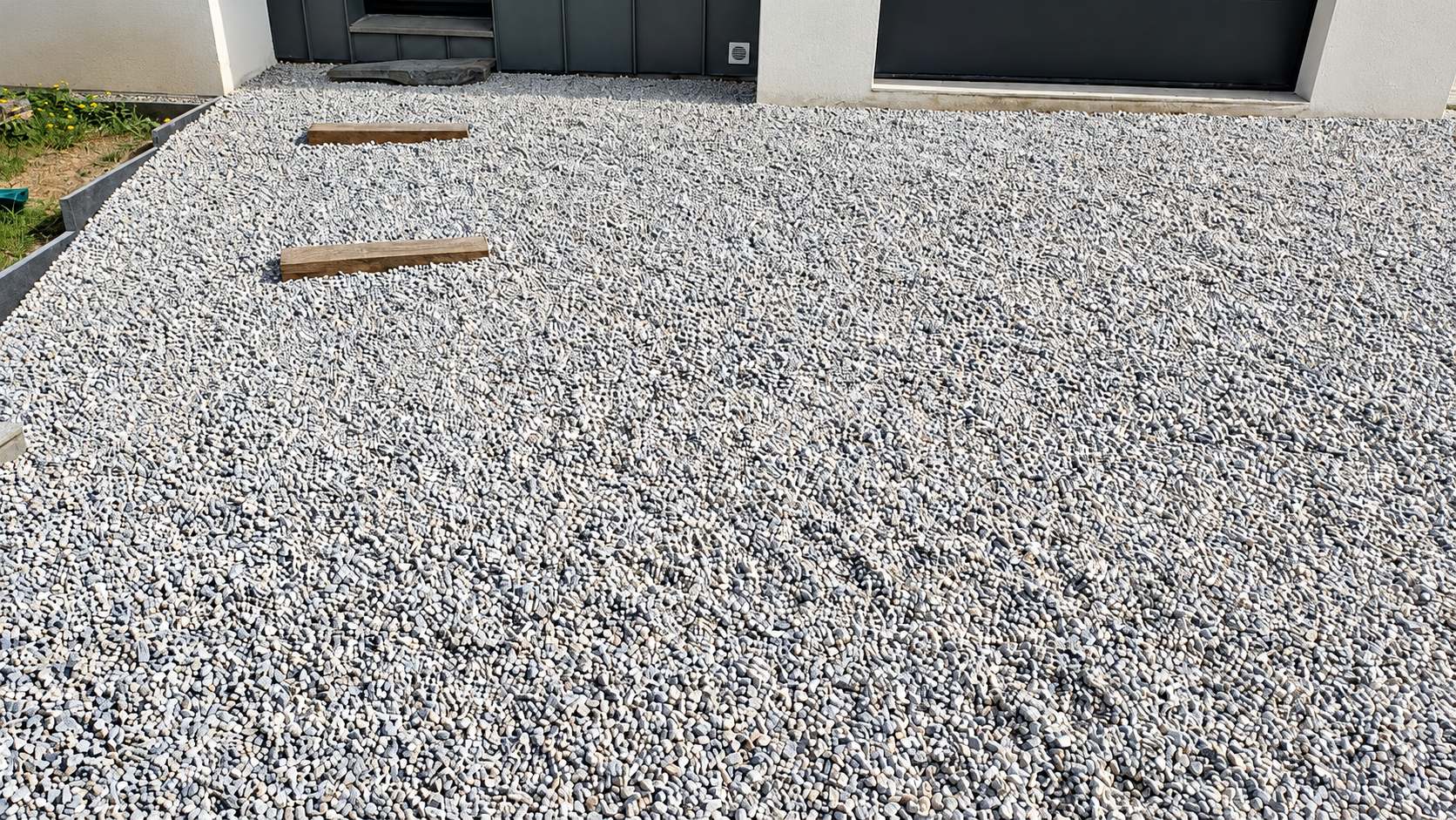 Parking et allée drainants en gravier gris après travaux à Sautron, avec marches en poutres de chêne